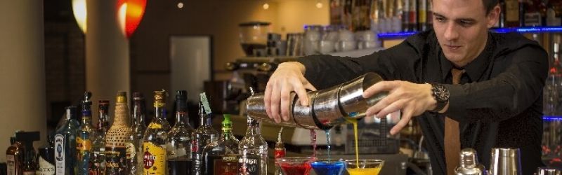 Der Bareeper mixt einen Cocktail an der Hotelbar
